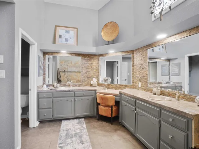 a large bathroom with a double vanity sink a mirror and a bathtub