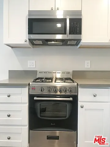 a stove top oven sitting inside of a kitchen