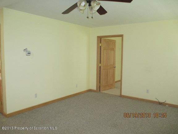 4270 Haas Pond Road Moscow, PA 18444 - Photo 4 of 15 an empty room with a ceiling fan and carpet