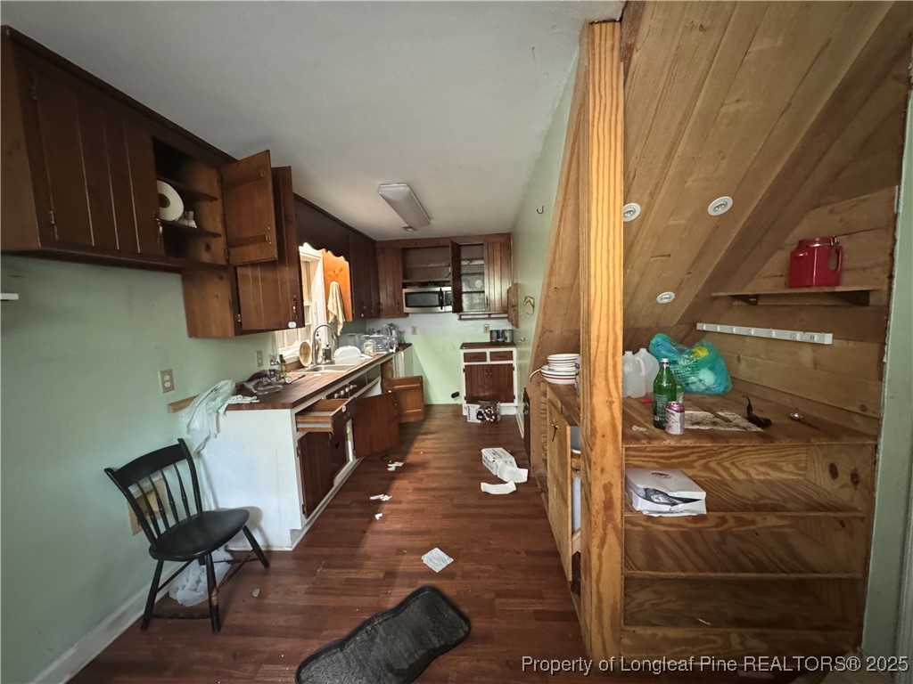 4199 Munsey Road Fayetteville, NC 28306 - Photo 7 of 24 a kitchen with stainless steel appliances wooden floor dining table and chairs