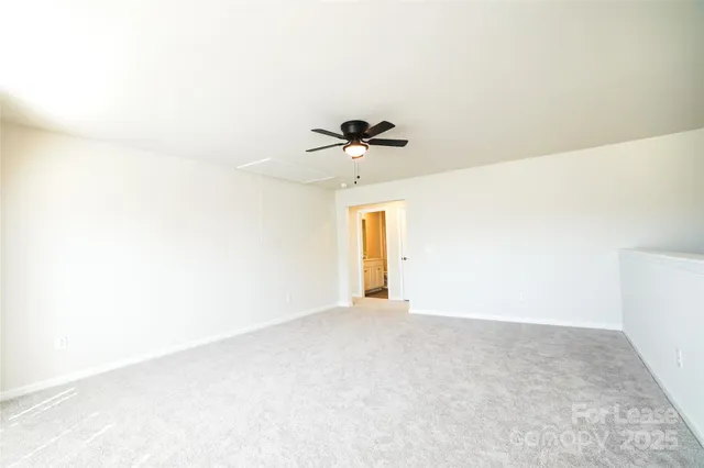 a view of a big room with windows and chandelier fan