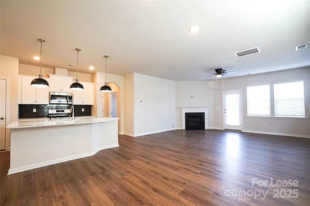 a kitchen with stainless steel appliances a table and chairs in it