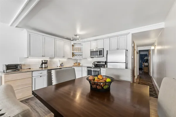 a kitchen with stainless steel appliances granite countertop a stove refrigerator and cabinets