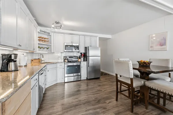 a kitchen with stainless steel appliances a stove a sink a microwave and a refrigerator