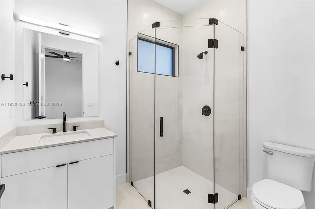 a bathroom with a shower sink vanity mirror and toilet