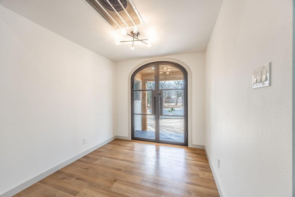 8713 Clay Hibbins Road Keller, TX 76248 - Photo 14 of 40 an empty room with wooden floor chandelier and windows