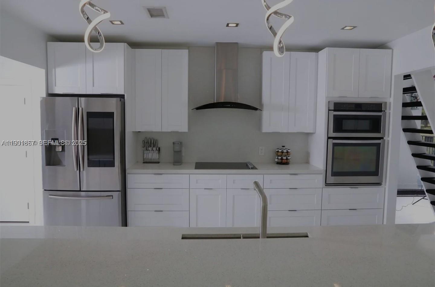 6003 Umbrella Tree Lane Tamarac, FL 33319 - Photo 11 of 22 a kitchen with kitchen island a counter top space a sink stainless steel appliances and cabinets