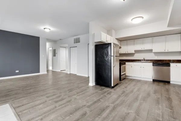 a kitchen with stainless steel appliances a refrigerator and wooden floor