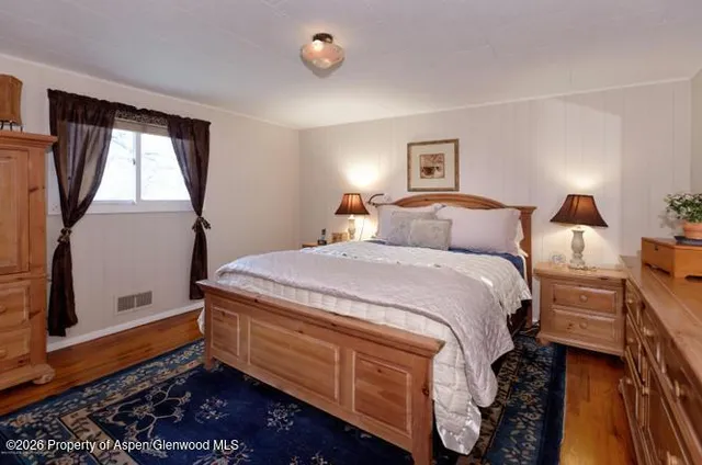 a bathroom with a toilet and a painting on the wall