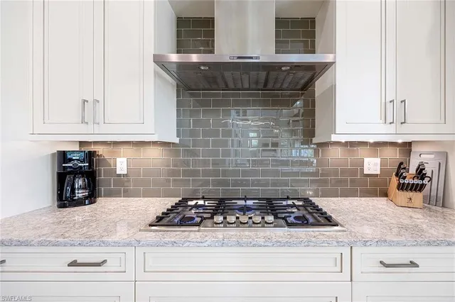 a kitchen with granite countertop a stove sink and cabinets