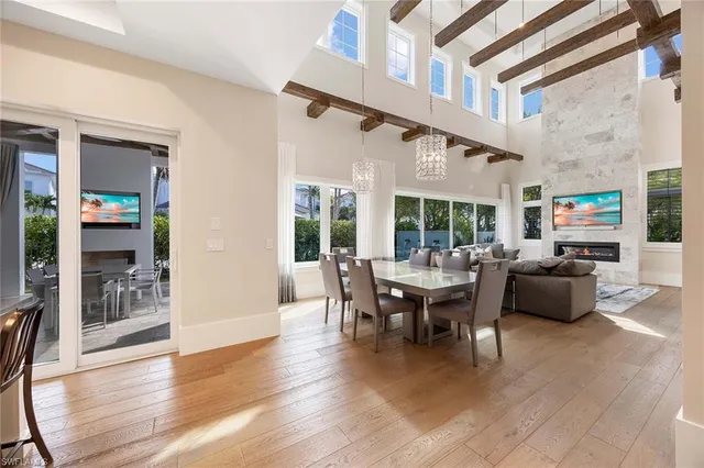 a living room with furniture a large window and wooden floor