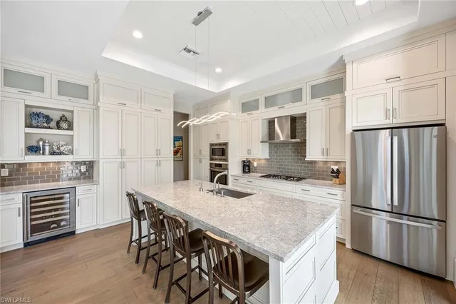 a kitchen with kitchen island a refrigerator stove microwave and cabinets