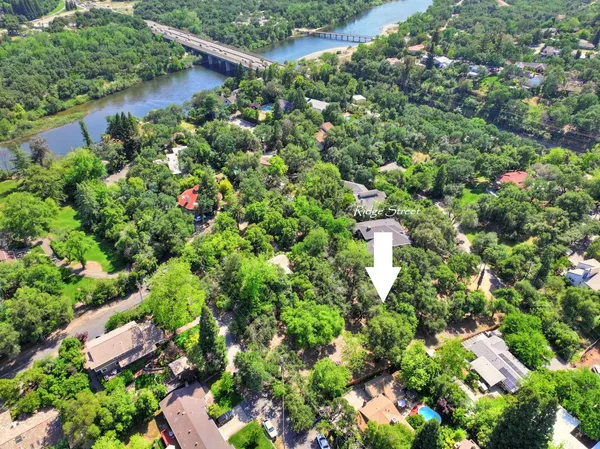 an aerial view of residential house with outdoor space and trees all around