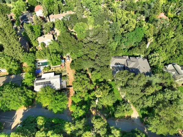 an aerial view of residential house with outdoor space and trees all around