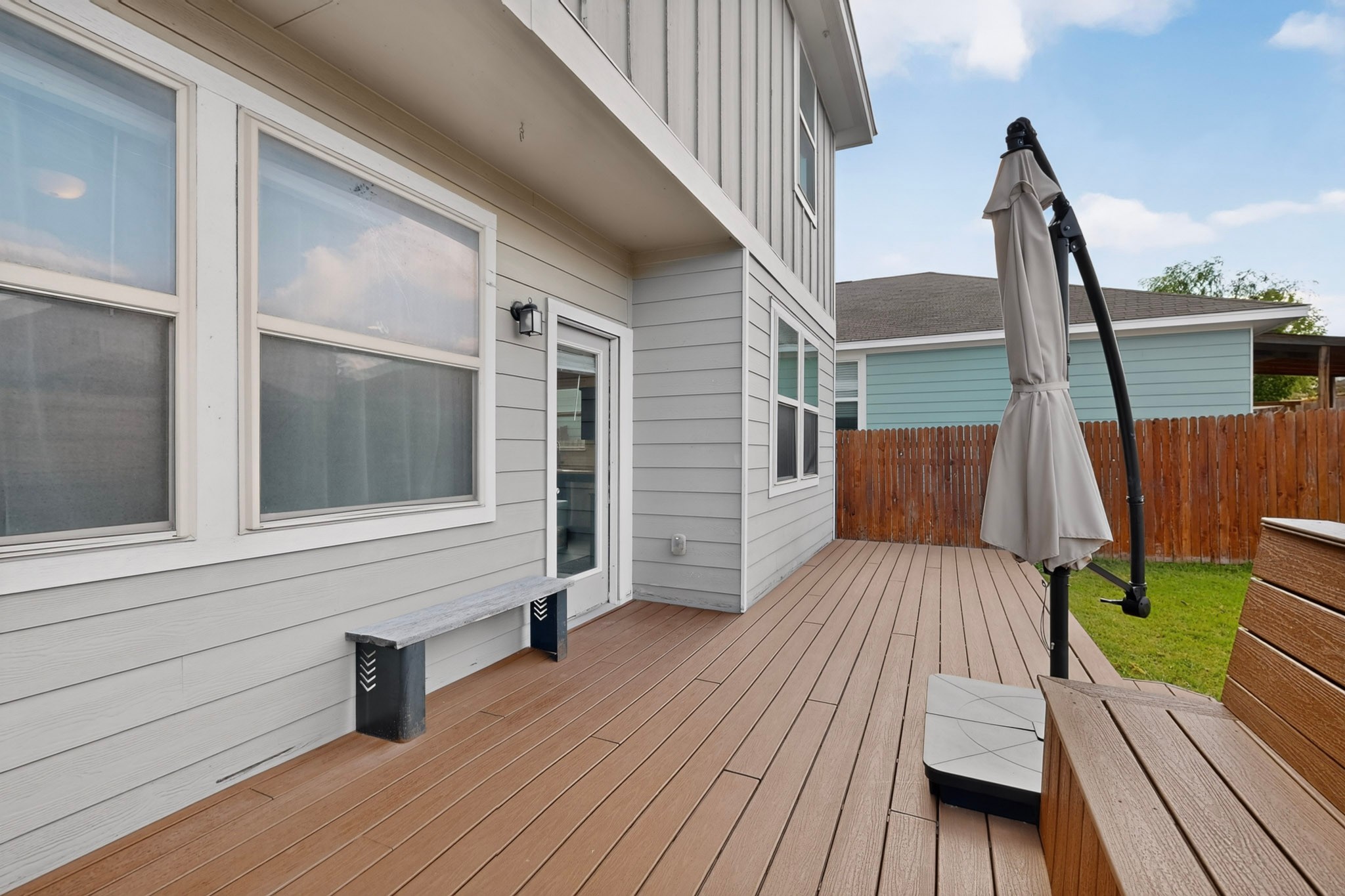 132 Wapiti Road Buda, TX 78610 - Photo 22 of 31 A spacious outdoor deck with wood-look flooring extends from the home's siding, perfect for entertaining.