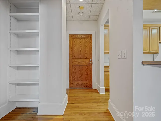 a view of a hallway with wooden floor and closet
