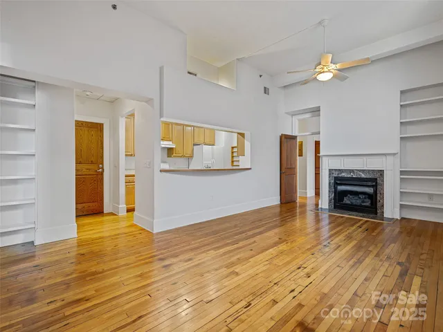 a view of empty room with wooden floor and fireplace