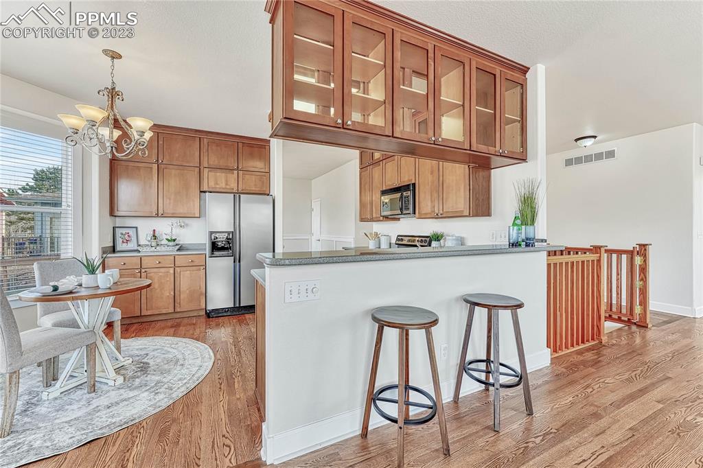 16946 Buffalo Valley Path Monument, CO 80132 - Photo 11 of 41 a kitchen with stainless steel appliances granite countertop a kitchen island a stove a table and chairs