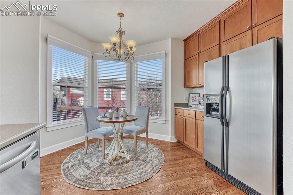 16946 Buffalo Valley Path Monument, CO 80132 - Photo 14 of 41 a dining room with furniture a kitchen a chandelier a wooden table and chairs
