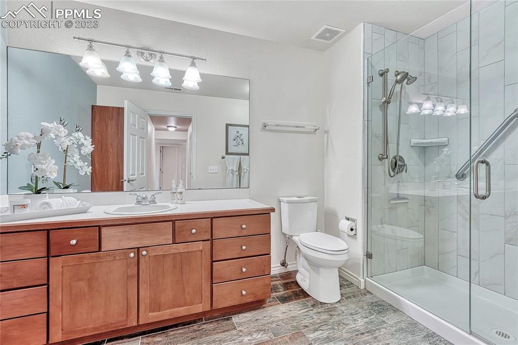 16946 Buffalo Valley Path Monument, CO 80132 - Photo 34 of 41 a bathroom with a granite countertop toilet sink and shower