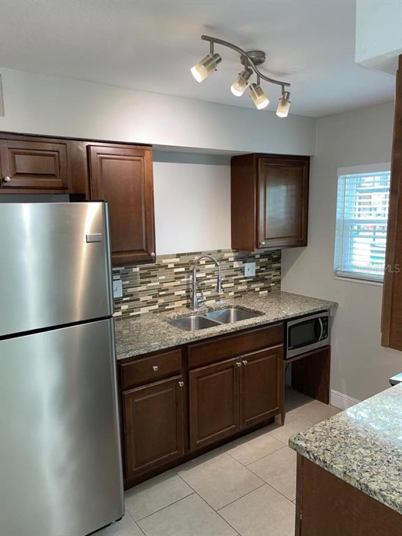5325 Curry Ford Road, Unit B101 Orlando, FL 32812 - Photo 12 of 22 a kitchen with stainless steel appliances granite countertop a refrigerator and a stove