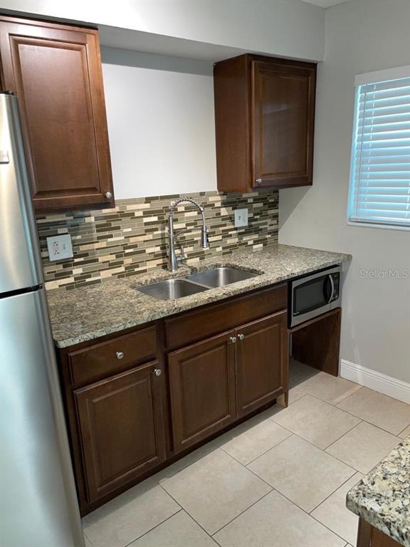 5325 Curry Ford Road, Unit B101 Orlando, FL 32812 - Photo 8 of 22 a kitchen with granite countertop a sink and a stove