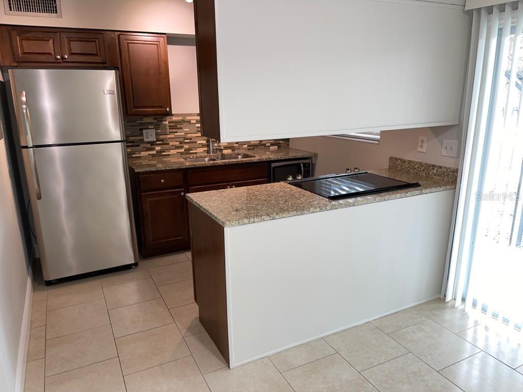 5325 Curry Ford Road, Unit B101 Orlando, FL 32812 - Photo 9 of 22 a kitchen with a stove top oven and refrigerator