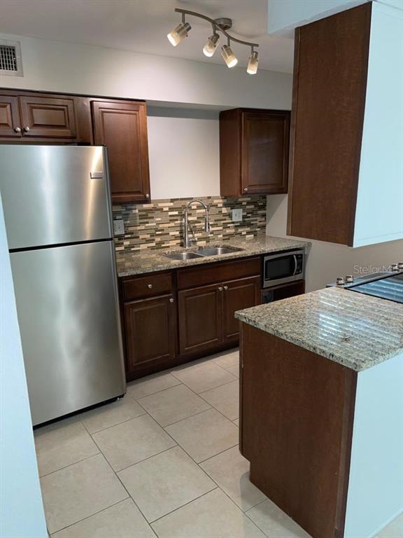 5325 Curry Ford Road, Unit B101 Orlando, FL 32812 - Photo 10 of 22 a kitchen with stainless steel appliances granite countertop a refrigerator and a stove