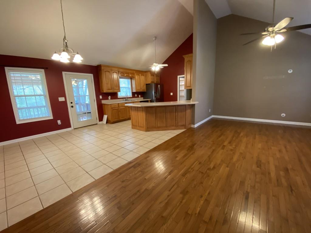 277 Harper Lane Royston, GA 30662 - Photo 11 of 42 a view of a kitchen with kitchen island a sink wooden floor and a large window