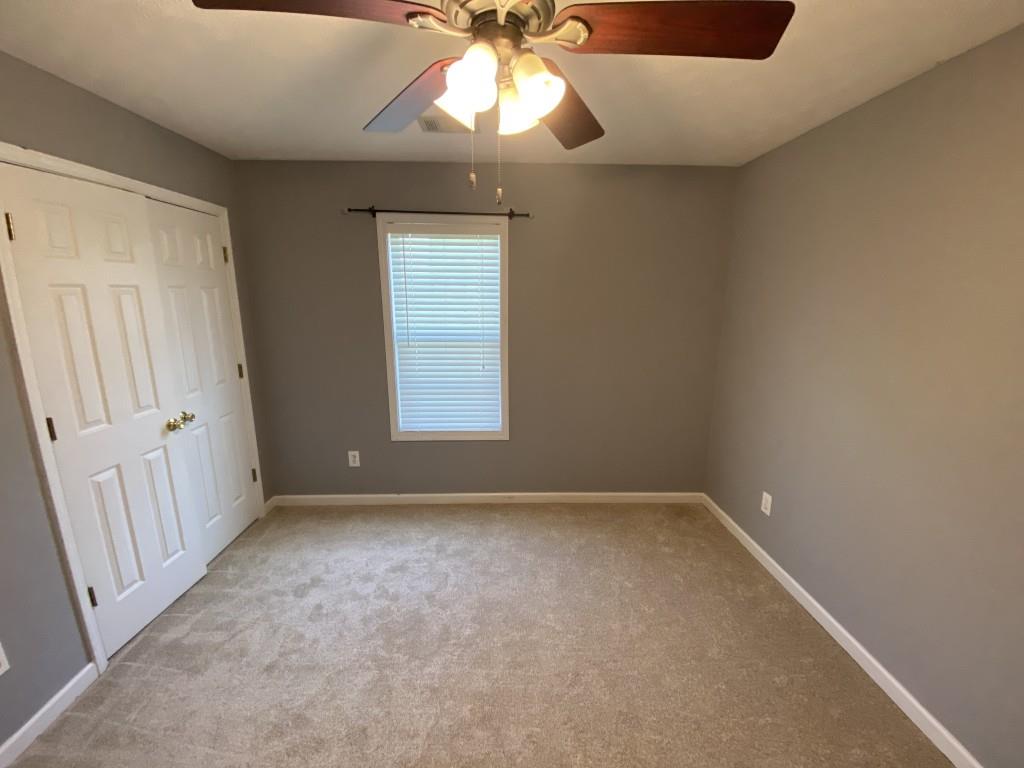 277 Harper Lane Royston, GA 30662 - Photo 26 of 42 an empty room with a chandelier fan and windows