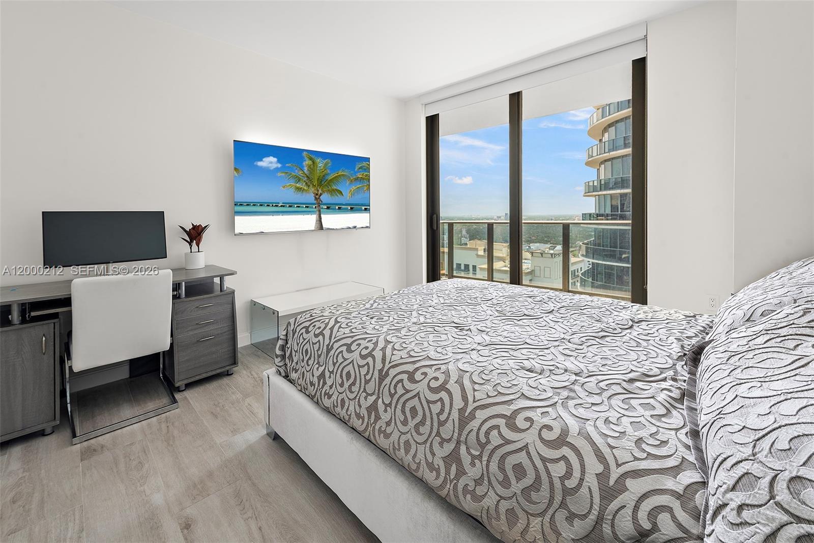 45 Southwest 9th Street, Unit 4006 Miami, FL 33130 - Photo 14 of 62 a bedroom with a large bed and a flat tv screen on dresser