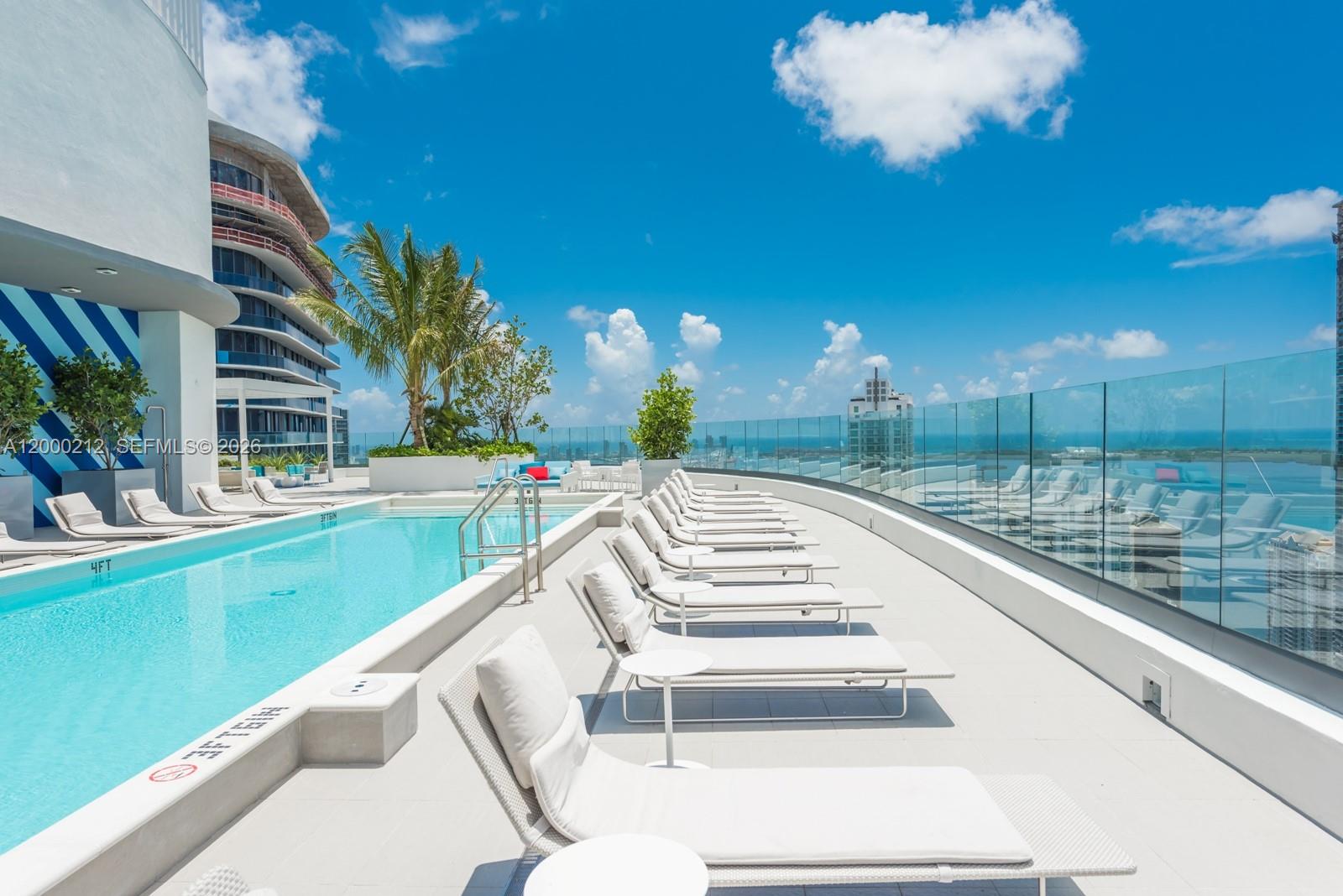45 Southwest 9th Street, Unit 4006 Miami, FL 33130 - Photo 60 of 62 a view of a swimming pool with a table and chairs