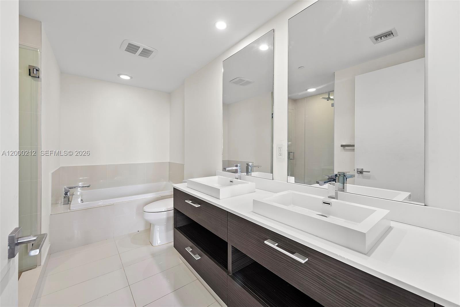 45 Southwest 9th Street, Unit 4006 Miami, FL 33130 - Photo 10 of 62 a bathroom with a sink a toilet a shower and a mirror