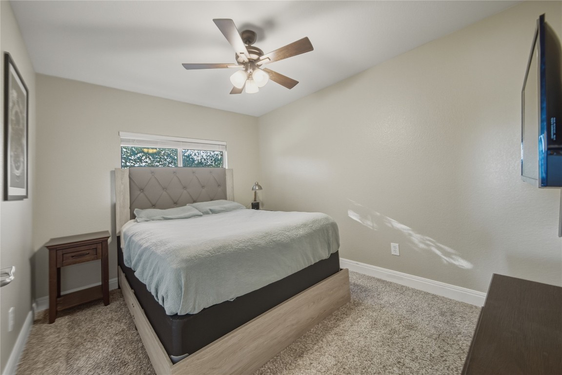 2207 Lauren Loop Leander, TX 78641 - Photo 18 of 26 a bedroom with a bed and a chandelier