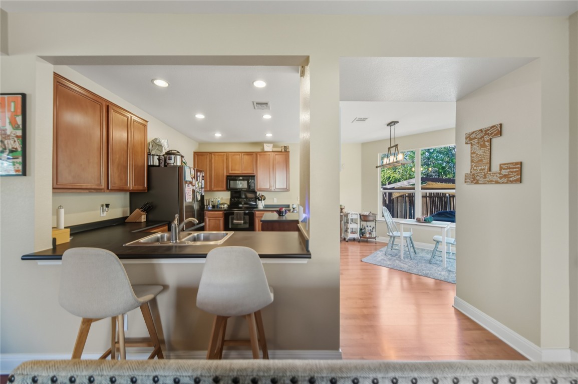 2207 Lauren Loop Leander, TX 78641 - Photo 6 of 26 a living room with furniture kitchen view and a wooden floor