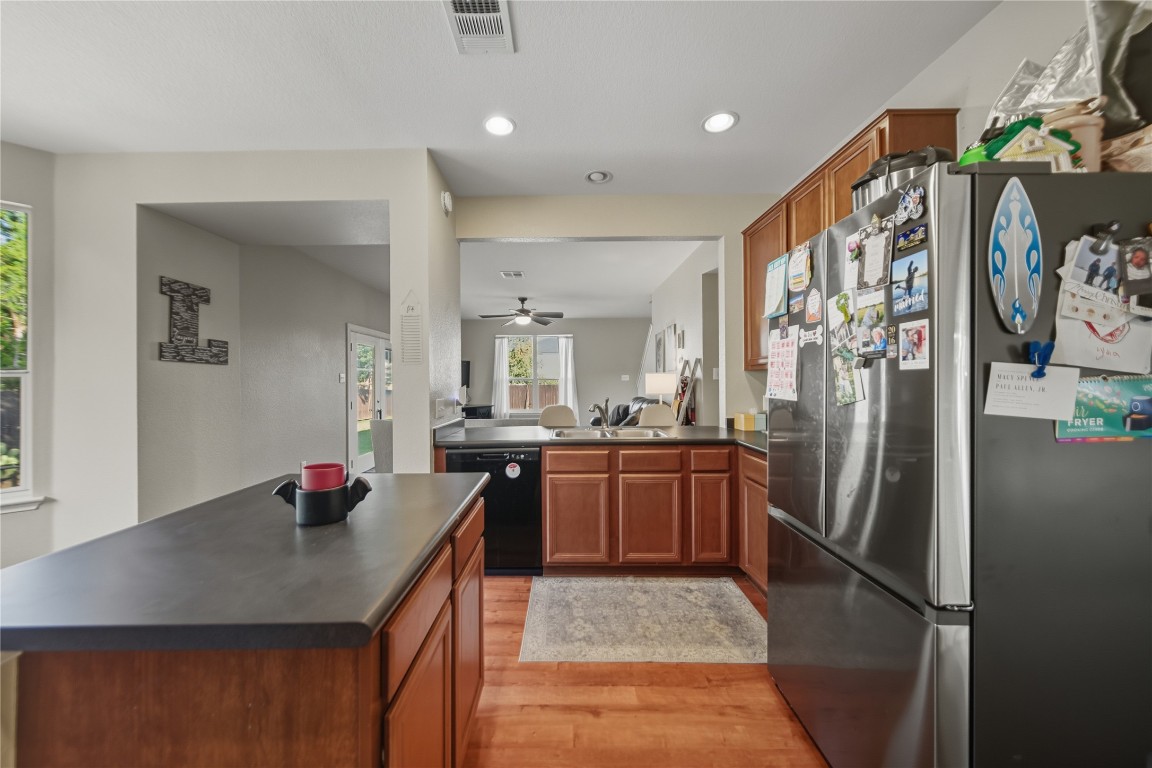 2207 Lauren Loop Leander, TX 78641 - Photo 7 of 26 a kitchen with stainless steel appliances granite countertop a sink refrigerator and cabinets