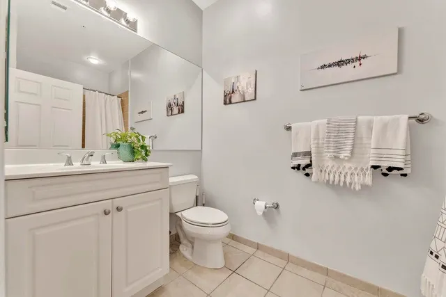 a bathroom with a granite countertop sink a toilet and a mirror