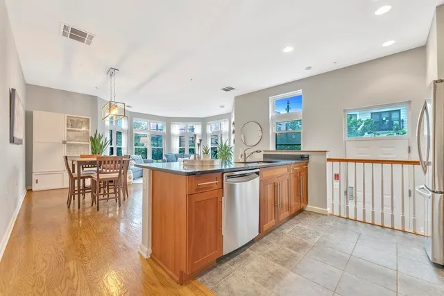 a kitchen with stainless steel appliances granite countertop a stove a sink a dining table and chairs