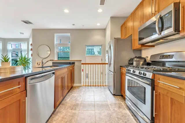 a kitchen with stainless steel appliances granite countertop a stove a sink and a refrigerator