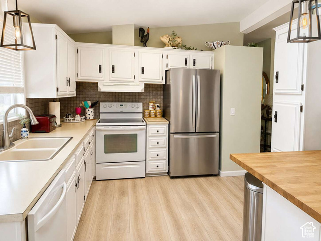 1526 North Dixie Downs Road, Unit 29 St. George, UT 84770 - Photo 2 of 16 White cabinetry with black hardware, wood-finish flooring, stainless steel French door refrigerator, white electric range, and a dual basin sink with a gooseneck faucet