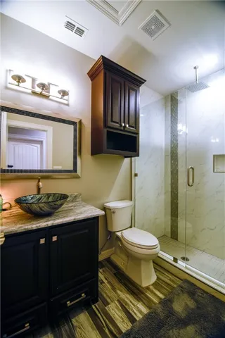 a bathroom with a granite countertop toilet sink and mirror