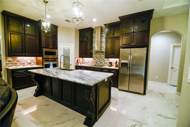a kitchen with stainless steel appliances granite countertop a stove refrigerator and cabinets