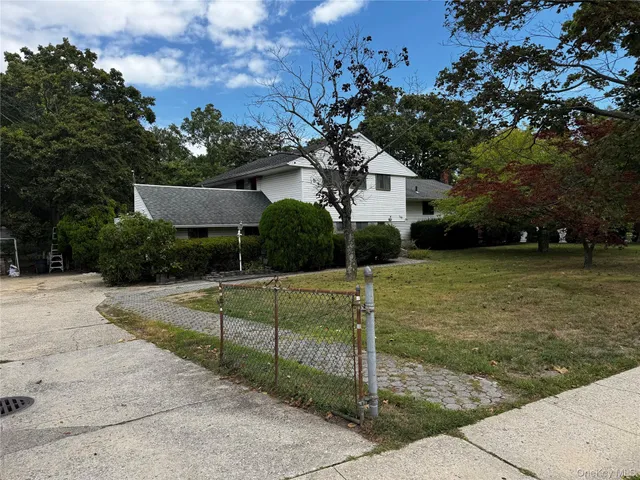 a view of a house with backyard and a tree