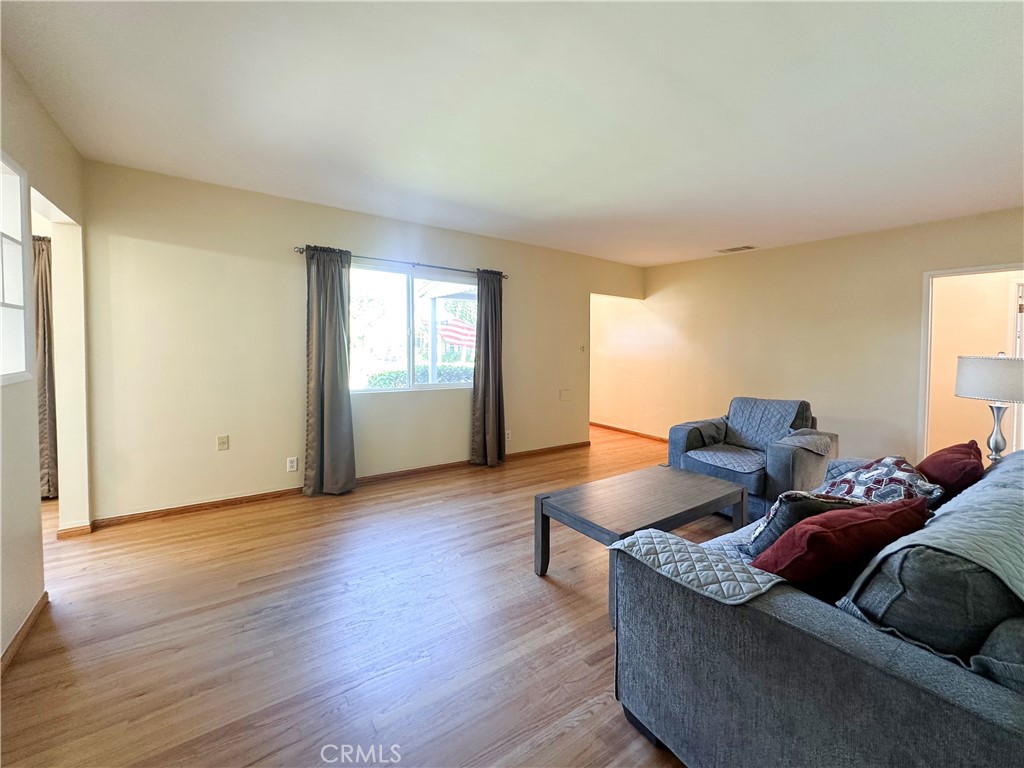 7508 Brookmill Road Downey, CA 90241 - Photo 4 of 20 a living room with couches and a potted plant next to a window