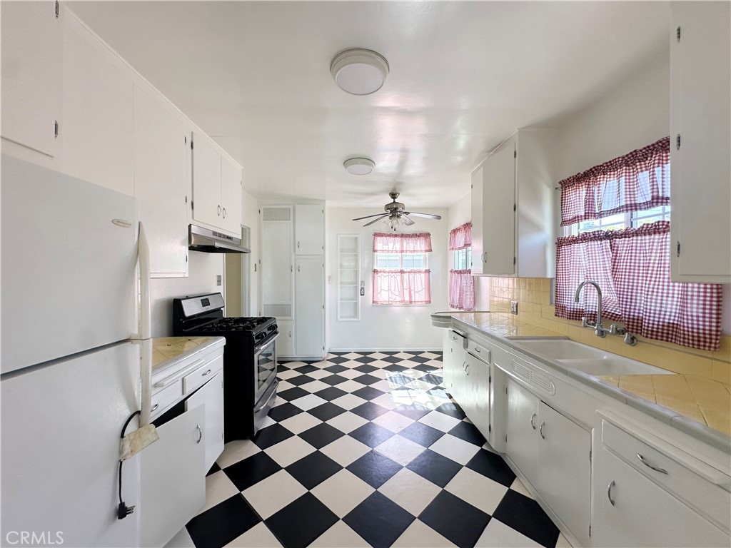 7508 Brookmill Road Downey, CA 90241 - Photo 9 of 20 a kitchen with a checkered floor and white cabinets