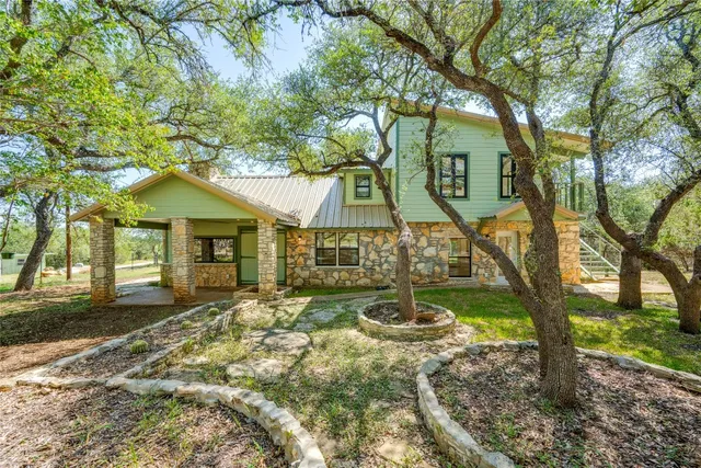 a backyard of a house with table and chairs