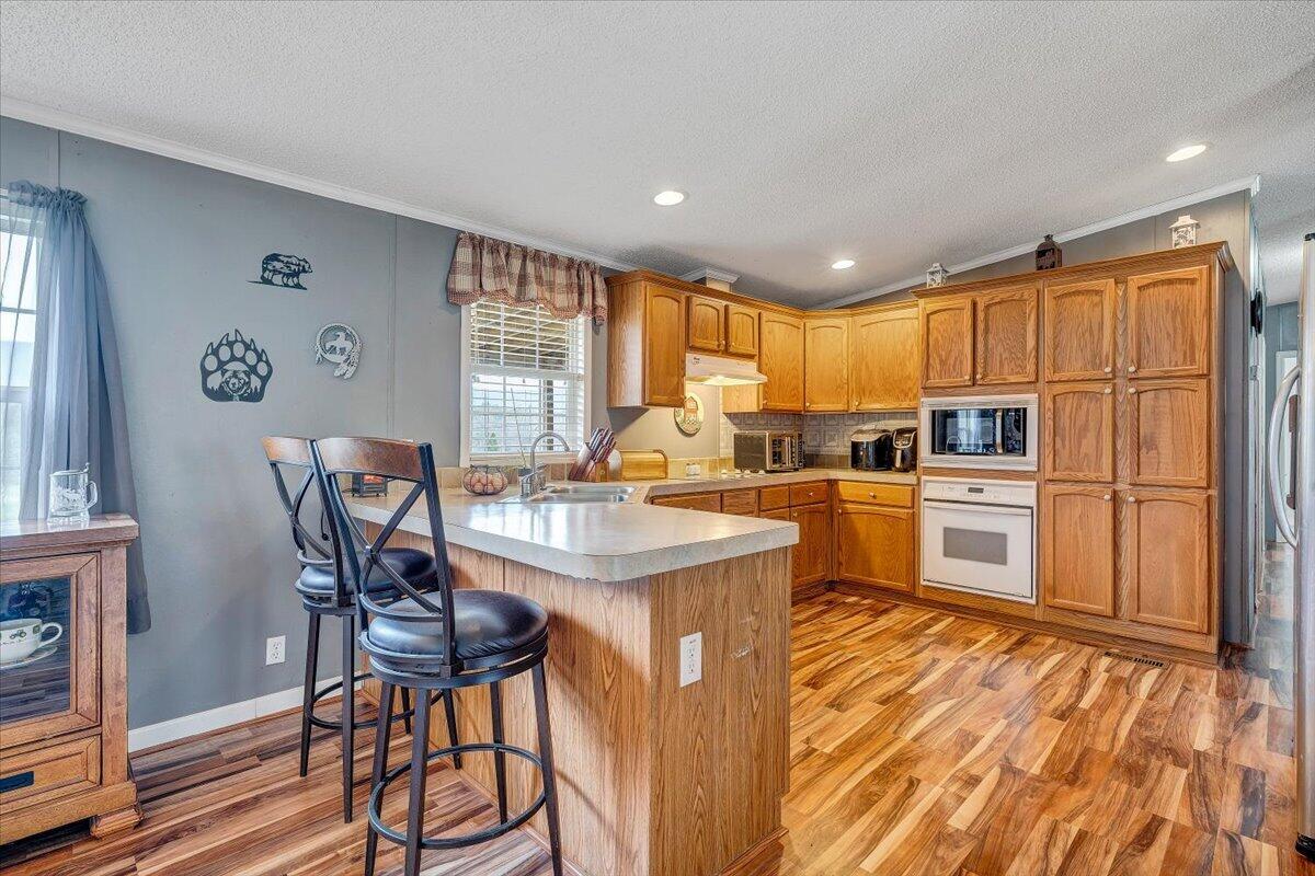 91 Homestead Road New Castle, VA 24127 - Photo 15 of 44 a kitchen with kitchen island granite countertop wooden floors and white stainless steel appliances