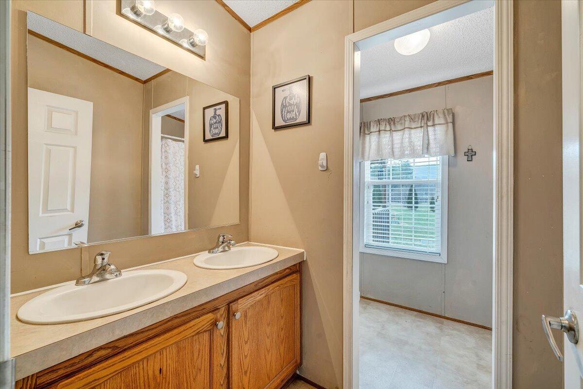 91 Homestead Road New Castle, VA 24127 - Photo 27 of 44 a bathroom with a granite countertop sink a mirror a vanity and a shower