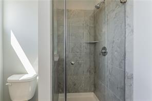 15107 Ryman Road Pflugerville, TX 78660 - Photo 22 of 34 a bathroom with a shower and a toilet