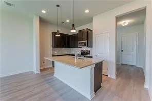 a kitchen with stainless steel appliances granite countertop a sink a stove and a wooden floors
